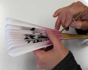 オリジナル扇子が1本から作れる「あつらえ扇子あや」糊が乾いたら、扇子を拡げる前に、折り目の間へ付属の竹串を差し込んで1折りづつやさしく丁寧に剥がします。