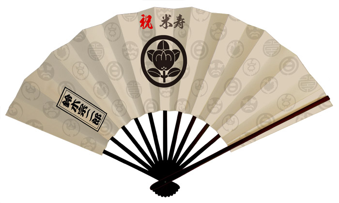 還暦米寿扇子　薄いベージュを背景に、多種多柄の百紋を薄く地紋風に配置し、真ん中に家紋を入れた粛々とした、威厳のある扇子です。　